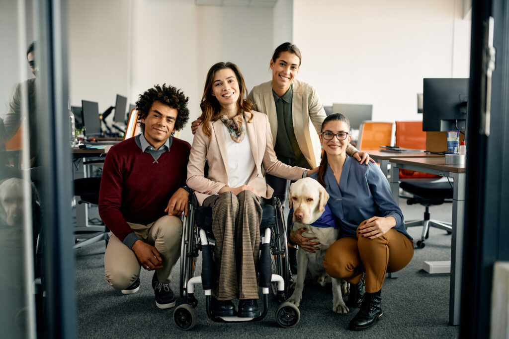 happy diverse business team with assistance dog at corporate office looking at camera. happy diverse business team with assistance dog at corporate office looking at camera.